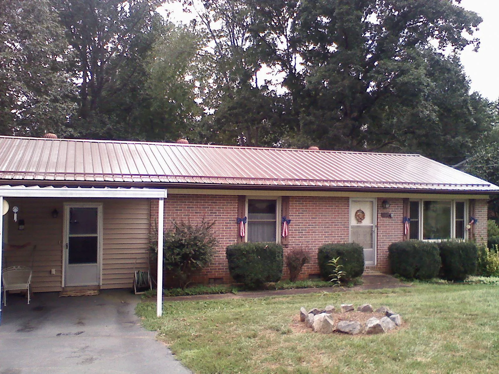 Bronze metal roof and carport on a brick ranch home — Roof Repair work by our crew in Rossville